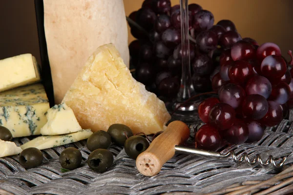Raffiniertes Stillleben von Wein, Käse und Trauben auf Korbblech in Nahaufnahme — Stockfoto