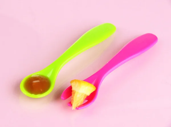 Color fork and spoon for baby food on pink background — Stock Photo, Image