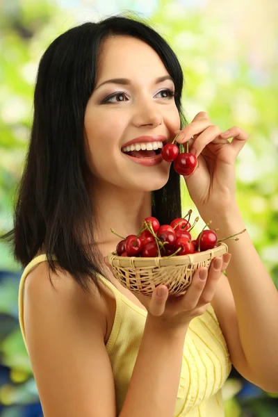 Menina com cerejas frescas no fundo natural — Fotografia de Stock