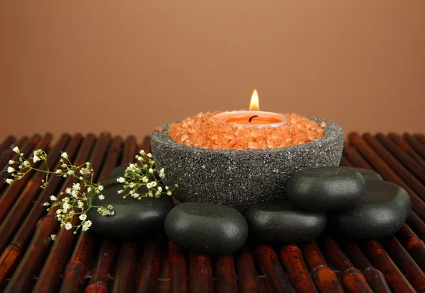 在石碗，用海洋盐，竹凉席，棕色背景上蜡烛 — 图库照片