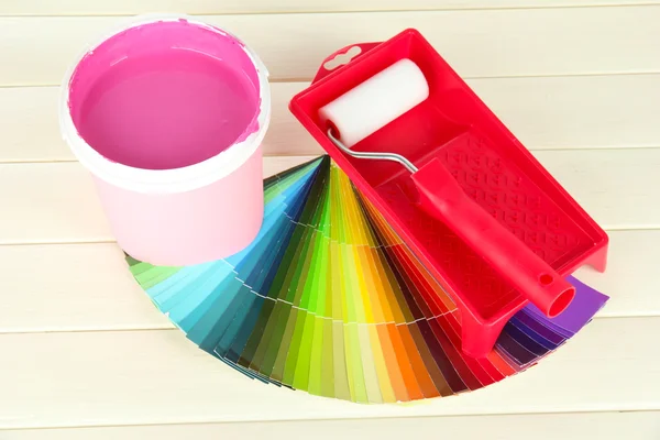 Set for painting: paint pot, paint-roller on white wooden table — Stock Photo, Image