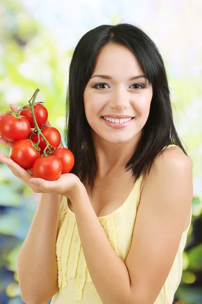 Flicka med färska tomater på naturliga bakgrund — Stockfoto