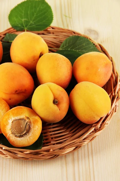 Apricots on wicker coasters on wooden table — Stock Photo, Image