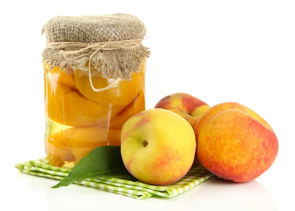 Jar of canned peaches and fresh peaches, isolated on white — Stock Photo, Image