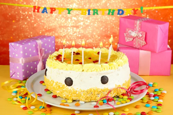 Happy birthday cake and gifts, on red background — Stock Photo, Image