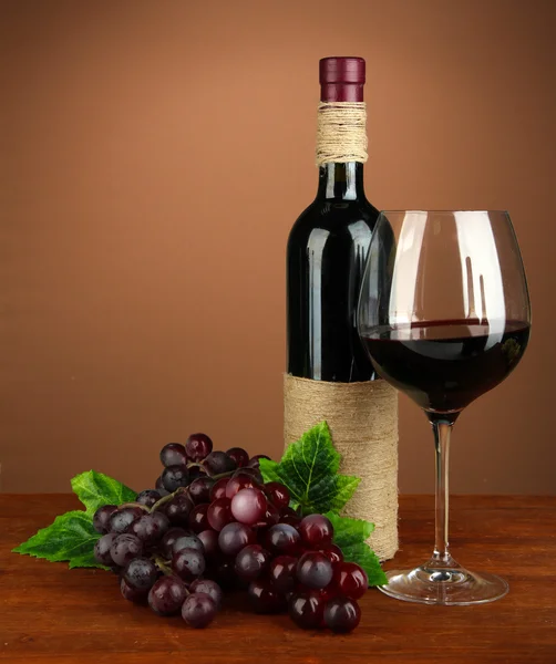 Composition bouteille de vin, verre de vin rouge, raisin sur fond de couleur — Photo