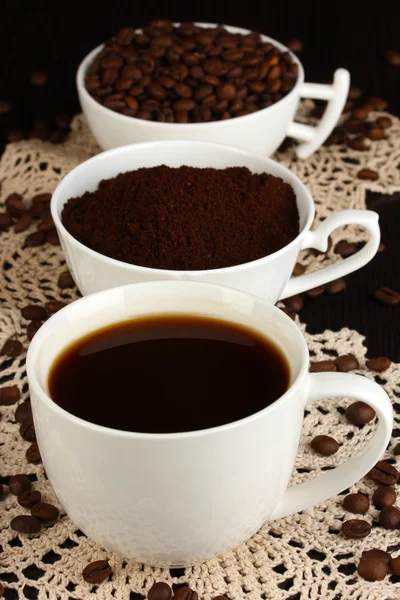 Diferentes tipos de café em três xícaras em mesa de madeira — Fotografia de Stock