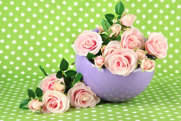 Maceta con flores sobre un fondo de tela verde — Foto de Stock