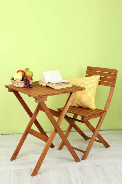 Mesa de madeira com frutas e livro sobre ele no quarto — Fotografia de Stock