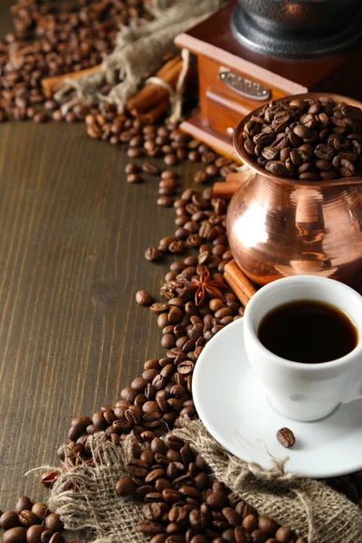 Cup of coffee, pot and grinder on wooden background — Stock Photo, Image