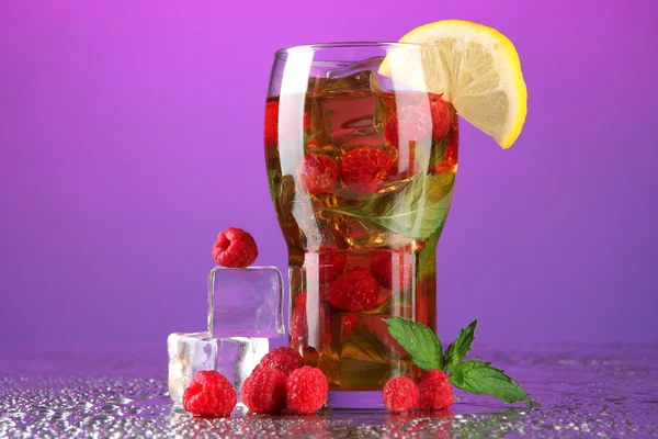 Iced tea with raspberries and mint on purple background — Stock Photo, Image