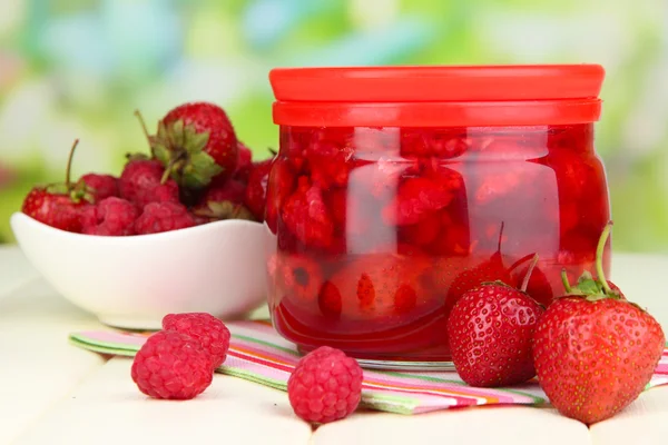 Hausgemachte Beerenmarmelade auf Holztisch auf hellem Hintergrund — Stockfoto