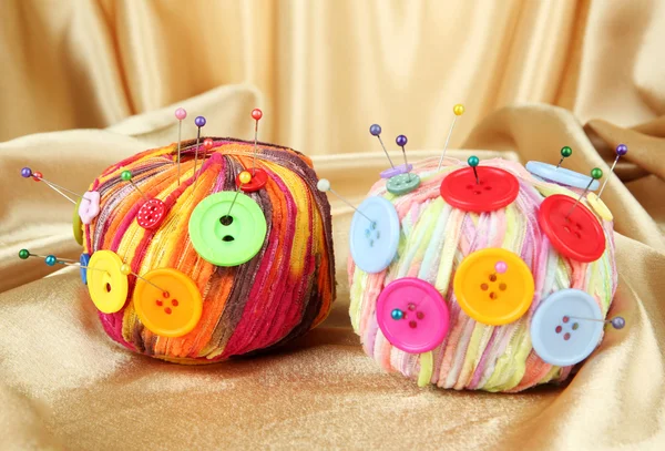 Kleurrijke knoppen en multicolor wol ballen, op weefsel achtergrondkleur — Stockfoto