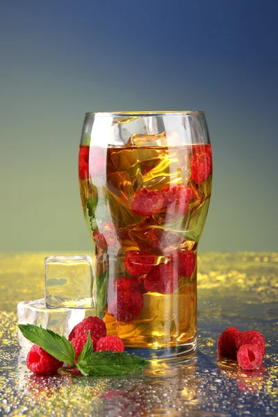 Iced tea with raspberries and mint on blue background — Stock Photo, Image