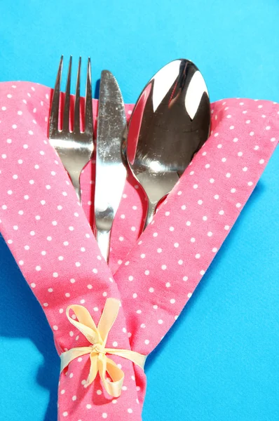 Haarukka, lusikka, veitsi lautasliinassa kirkkaalla taustalla — kuvapankkivalokuva
