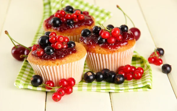 Beyaz ahşap masa üzerinde meyveleri ile lezzetli muffins — Stok fotoğraf