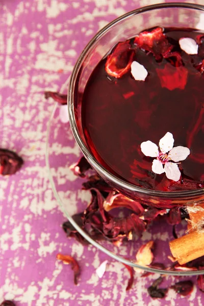 Tisane dans une tasse en verre, sur fond de bois couleur — Photo