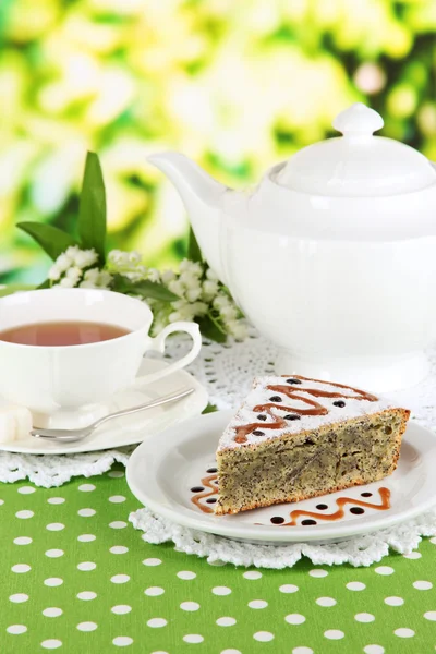 Délicieux gâteau aux graines de pavot avec tasse de thé sur la table sur fond lumineux — Photo