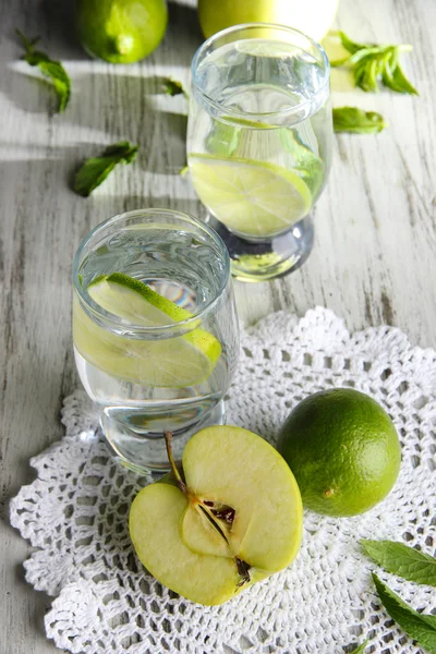 Glazen cocktail met kalk op servet op licht houten tafel — Stockfoto