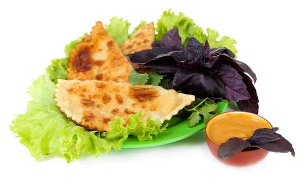 Chèques savoureux avec des herbes fraîches sur l'assiette, isolé sur blanc — Photo