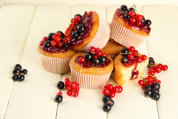 Tasty muffins with berries on white wooden table — Stock Photo, Image
