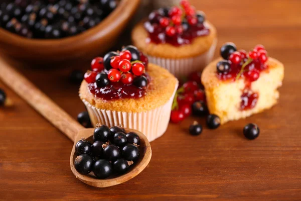 Tasty muffins with berries on wooden table — Stock Photo, Image