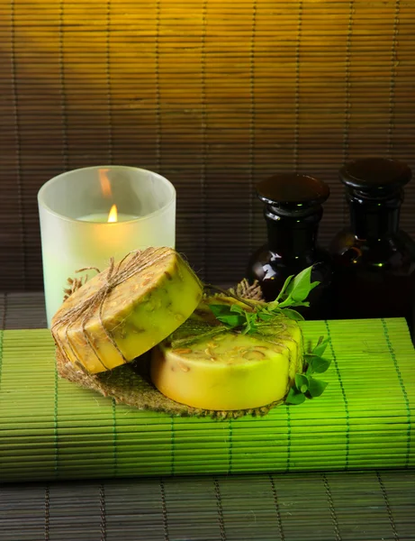 Hand made soap and candle on bamboo mat background — Stock Photo, Image