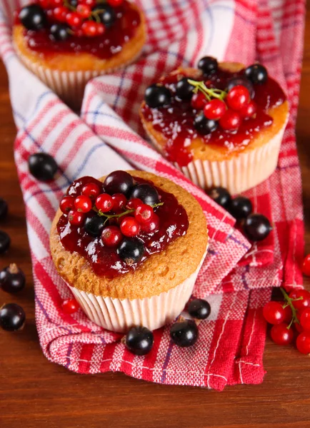 Smakelijke muffins met bessen op houten tafel — Stockfoto