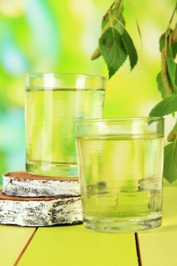 Huş ağacı sap yeşil zemin üzerine ahşap masa üzerinde bardak