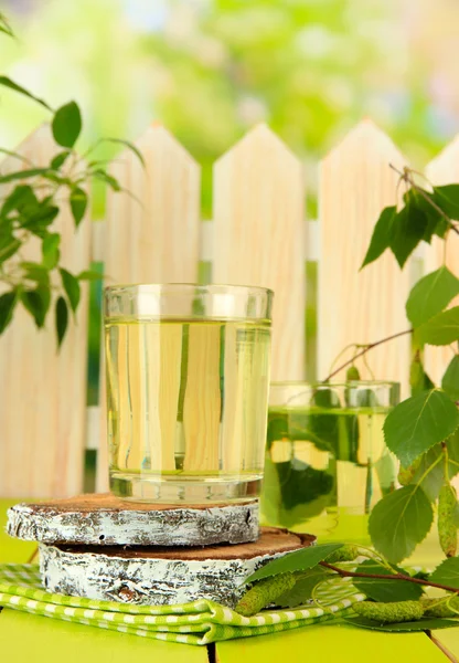 Vasos de savia de abedul sobre mesa de madera verde —  Fotos de Stock