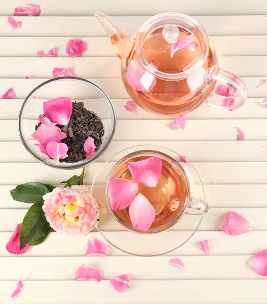 Hervidor de agua y taza de té de rosa de té en servilleta sobre fondo de madera — Foto de Stock