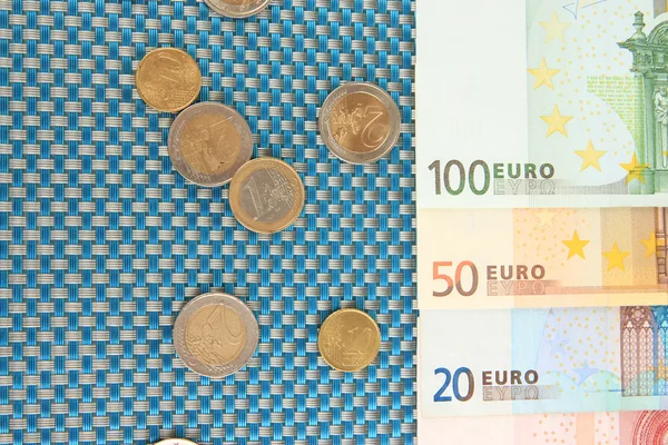 Eurobankbiljetten en eurocent op blauwe achtergrond — Stockfoto