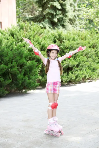 Petite fille en patins à roulettes au parc — Photo