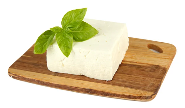 Sheep milk cheese with basil on cutting board, isolated on white — Stock Photo, Image