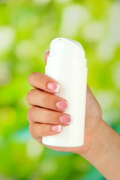 Donna che applica la crema su mani su sfondo luminoso — Foto Stock