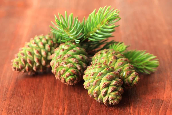 Cones verdes e abeto em fundo de madeira — Fotografia de Stock