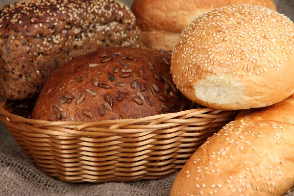 Gebackenes Brot im Weidenkorb auf Klette Hintergrund — Stockfoto