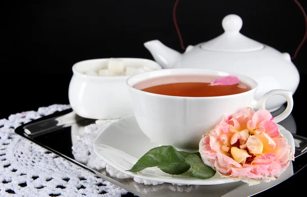 Bollitore e tazza di tè da tè rosa su vassoio metallico su tovagliolo sfondo nero — Foto Stock