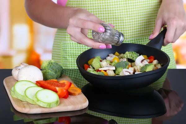 Manos cocinando ragú de verduras en sartén en la cocina —  Fotos de Stock