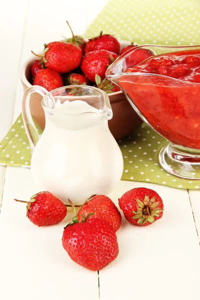 Homemade strawberry jam, on napkin, on color wooden background — Stock Photo, Image