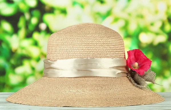 Bonito chapéu de verão com flor no fundo verde — Fotografia de Stock