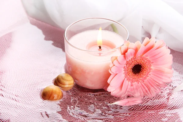 Розовая свеча с цветком в воде — стоковое фото