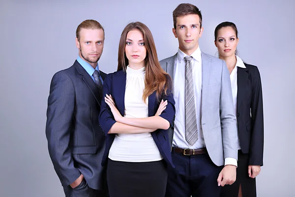 Equipe de negócios em fila no fundo cinza — Fotografia de Stock