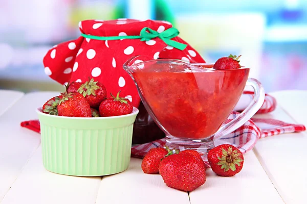 Hausgemachte Erdbeermarmelade, auf Serviette, auf farbigem Holztisch, auf hellem Hintergrund — Stockfoto