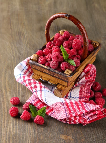 Ripe sweet raspberries in basket on wooden background — Stock Photo, Image