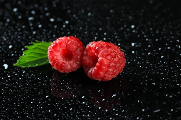 Reife süße Himbeeren mit Tropfen auf dunklem Hintergrund — Stockfoto