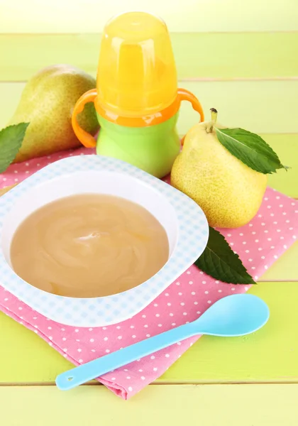 Saboroso purê de frutas do bebê e mamadeira na mesa de madeira — Fotografia de Stock