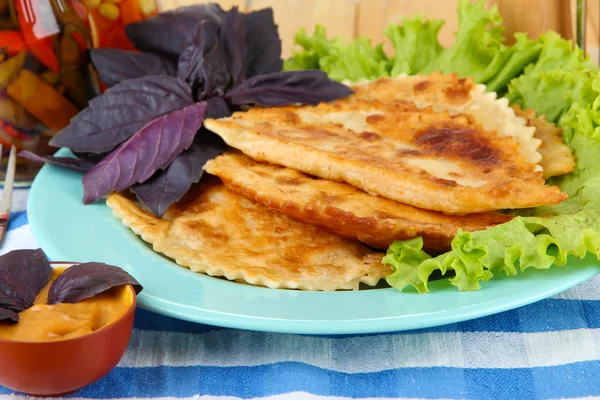 Sabrosos chebureks con hierbas frescas en el plato, primer plano —  Fotos de Stock