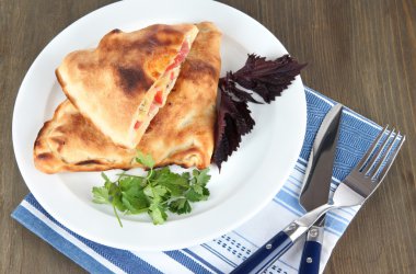 Pizza calzone peçete ahşap masa üzerinde plaka üzerinde
