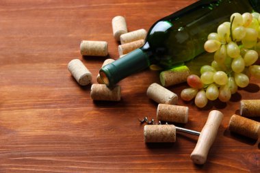 şişe şarap, üzüm ve ahşap zemin üzerinde mantarlar